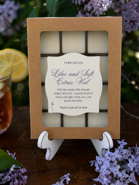 Wax melts in Kraft paper box with clear plastic window and a label that says Lilac and Soft Citrus Veil