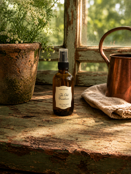 Room spray in an amber glass bottle with a label that says The Old Greenhouse